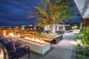Custom landscape and hardscape commercial patio area with brick pavers, large bar area, expansive fire pits and seating area