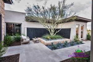 Custom front yard hardscape with large pebble wall fountain and desert landscape with seating