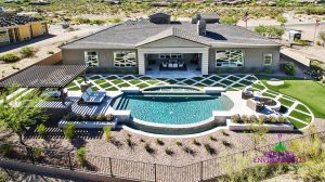 Arial view of custom backyard landscape with swimming pool and unique grass pattern