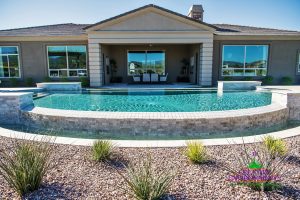 Custom backyard landscape with infinity pool with water features surrounded by desert landscape