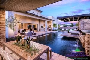 Custom outdoor landscape in Arizona with zero edge swimming pool with floating bed and metal pergola