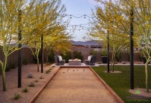 Custom outdoor landscape in Arizona showing a bocce ball court surrounded by desert landscape and rope lighting above