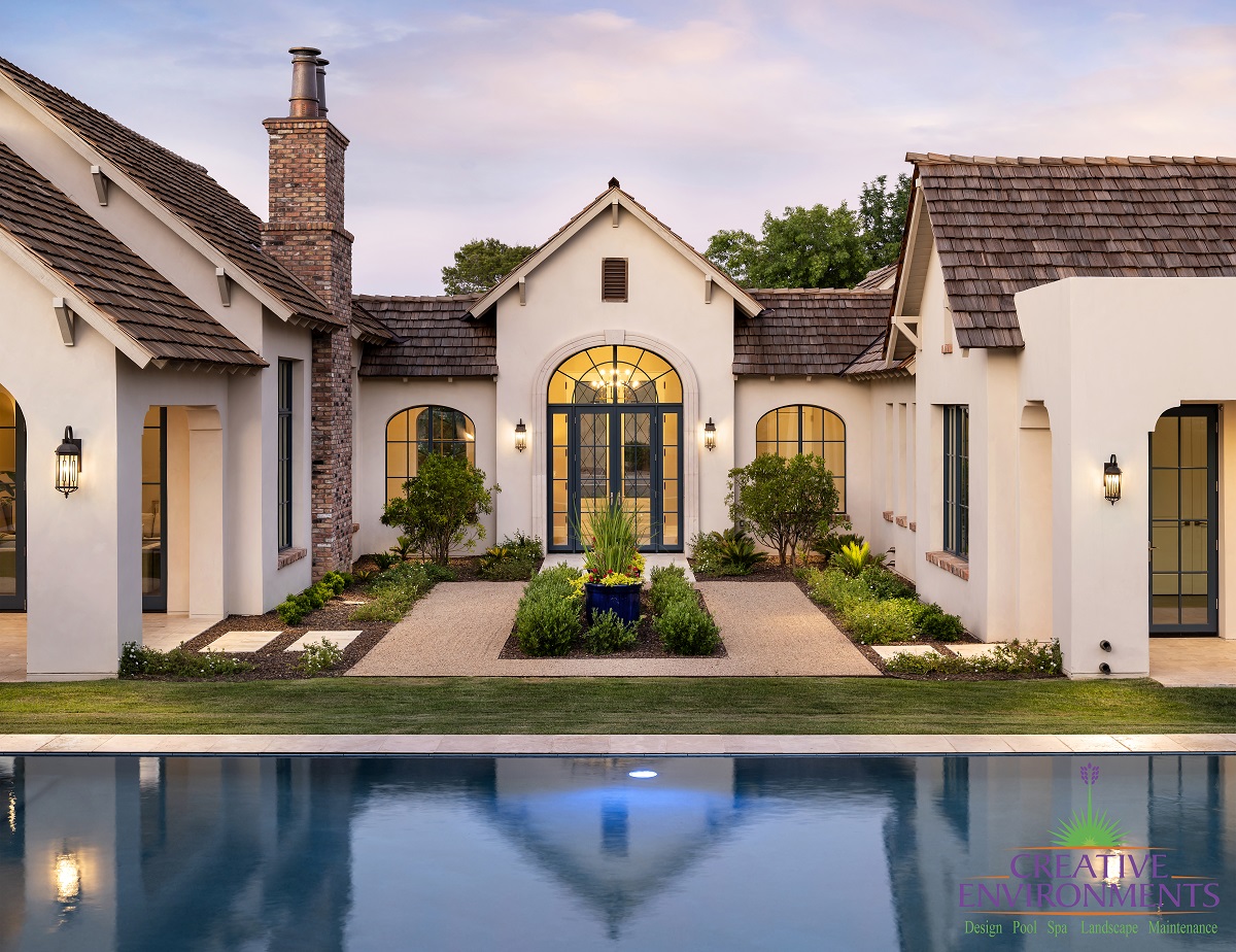 Custom backyard design landscape with zero edge swimming pool by custom backyard and large house