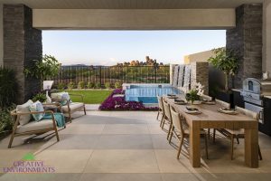 Creative Environments design and landscape at Sereno Canyon Enclave Model showing backyard patio with dining and glass swimming pool