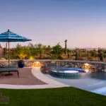 Custom backyard design with natural stone retention wall, curved pool and spa within pool.