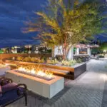 Custom backyard design with modern fire pits, multiple seating areas and patterned paver design.