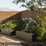 Custom backyard design with herb garden and metal planters.