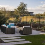 Custom backyard design with metal fencing, natural stone steps and artificial turf.