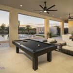 Custom backyard design with outdoor entertainment area, pool table and multiple seating areas.