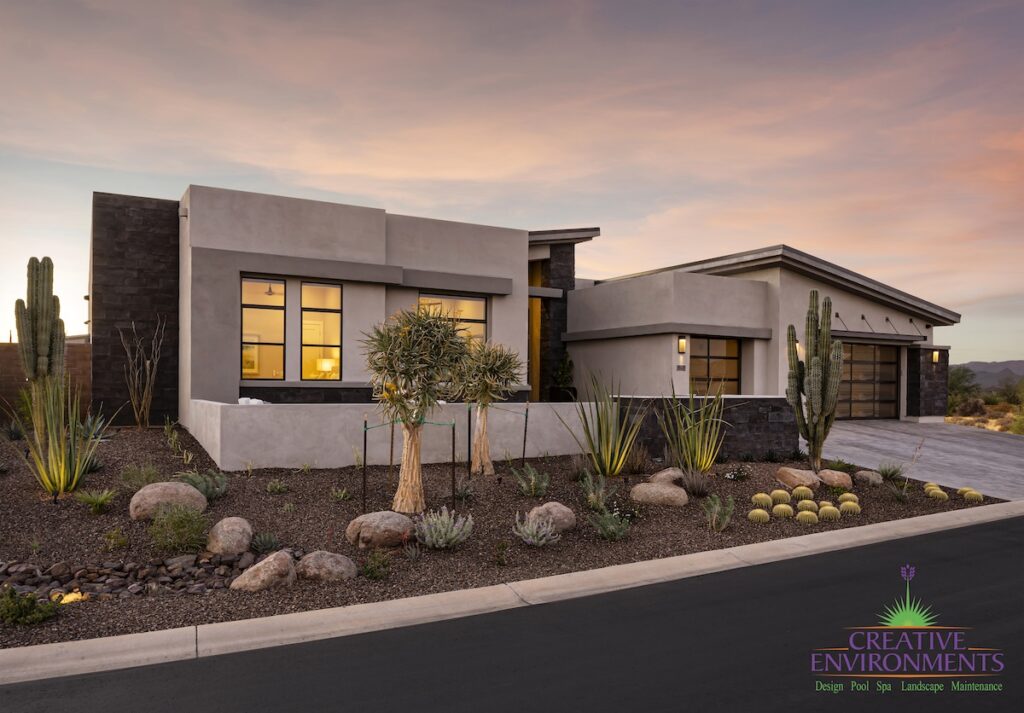 Custom front yard design with desert plants, boulders and up lighting.