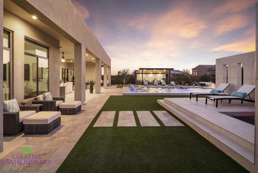 Backyard design with artificial turf, natural stone steps and angled shade structure.