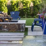 Custom backyard design with natural stone columns, Jesus steps and large, square fire pit.