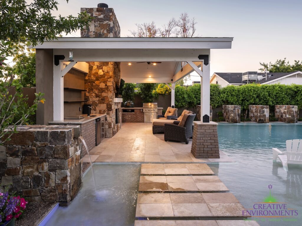 Custom backyard design with water columns, Jesus steps and floor-to-ceiling natural stone fireplace.