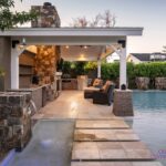 Custom backyard design with water columns, Jesus steps and floor-to-ceiling natural stone fireplace.