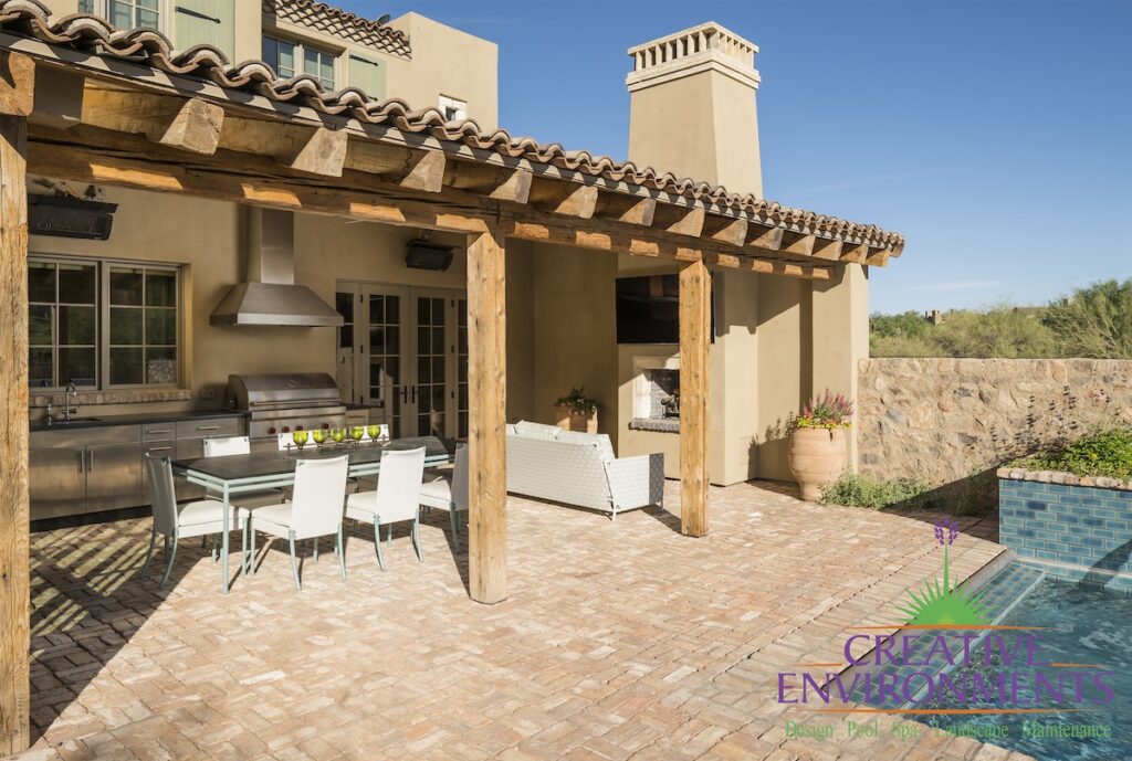 Custom backyard design with outdoor kitchen -- complete with hood, outdoor bbq, storage and outdoor TV.