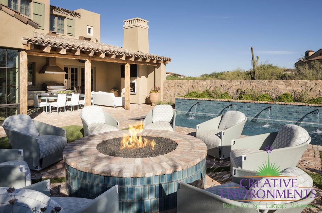 Custom backyard design with stone wall, circular fire pit and multiple seating areas.