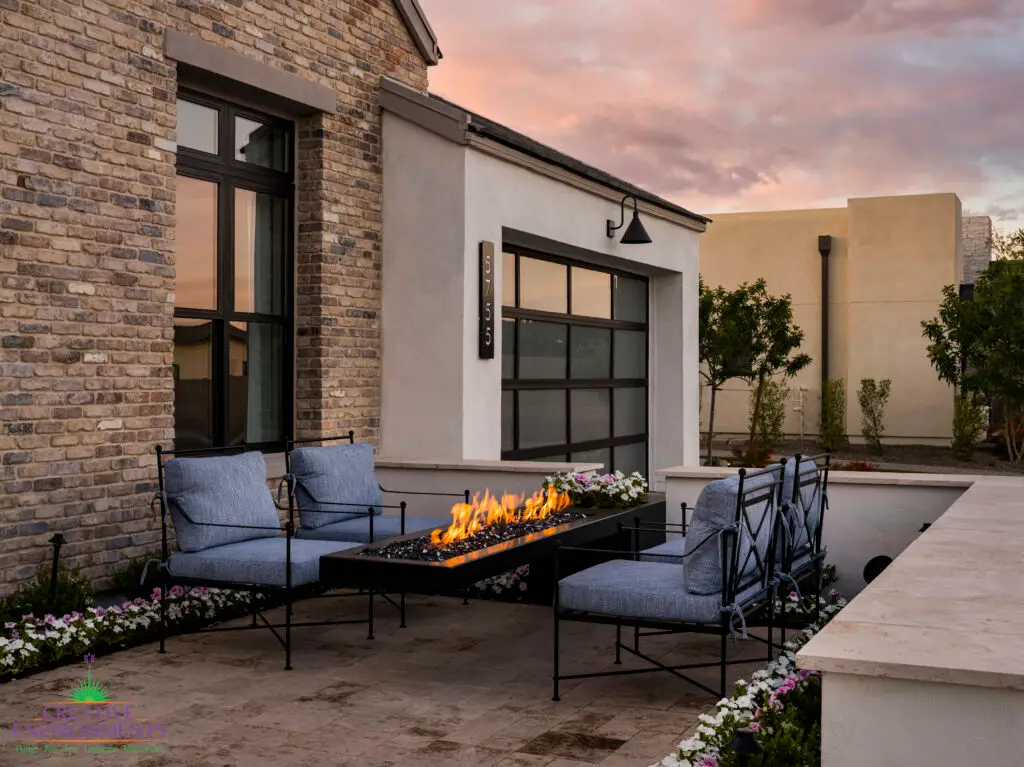Custom front yard design with cantilevered fire table, annuals and natural stone privacy wall.