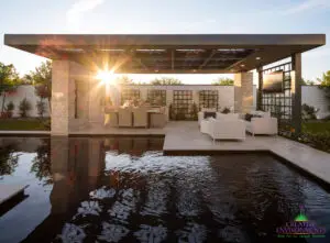 Custom backyard design with custom metal shade structure, metal trellis and black pool.