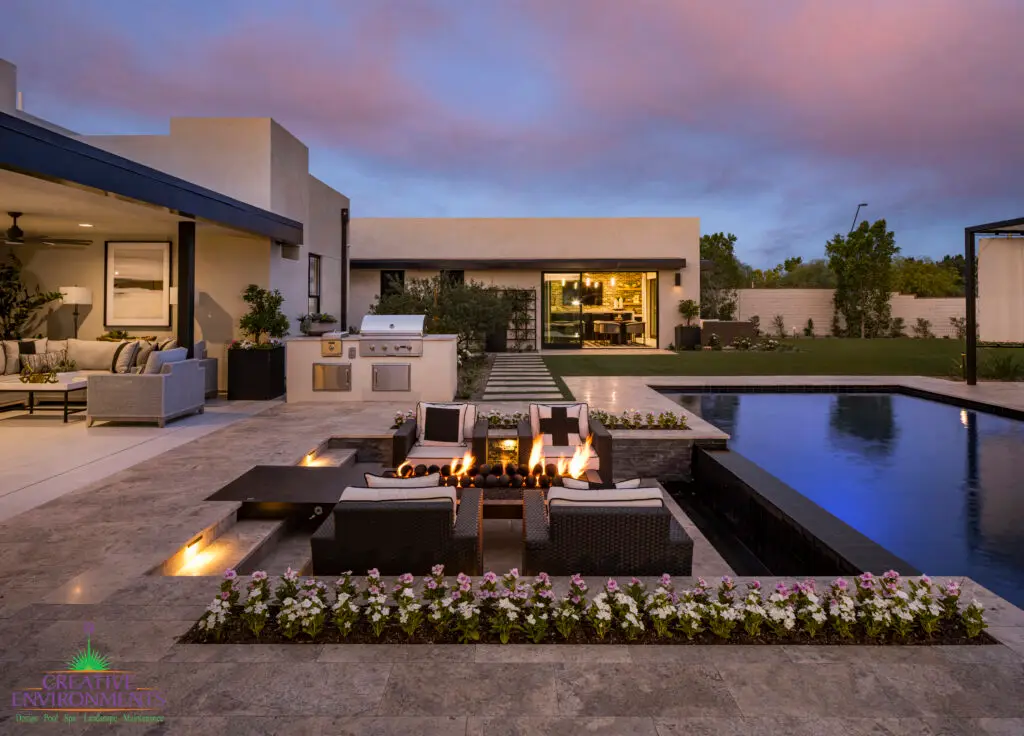 Custom backyard design with flowers, sunken fire pit and multiple seating areas.