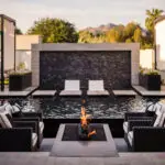Custom backyard design with sunken fire pit, Jesus steps and black water wall into pool.