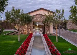 Custom community amenities with linear water feature, tree uplighting and organized planting.