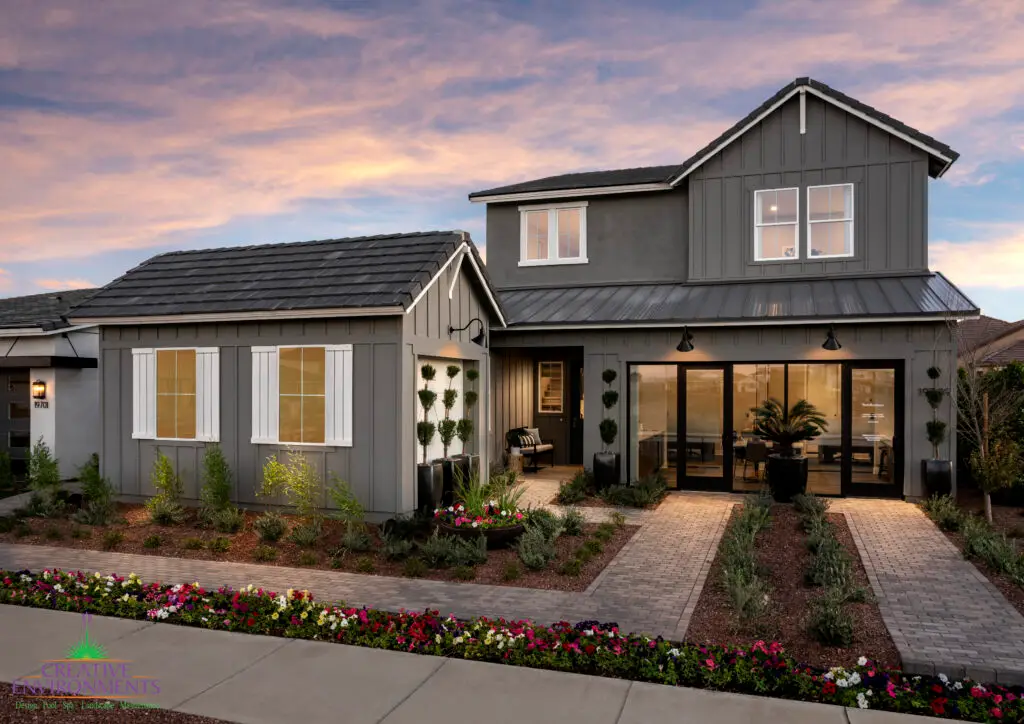 Custom front yard design with brick paver walkway, annuals and topiaries.