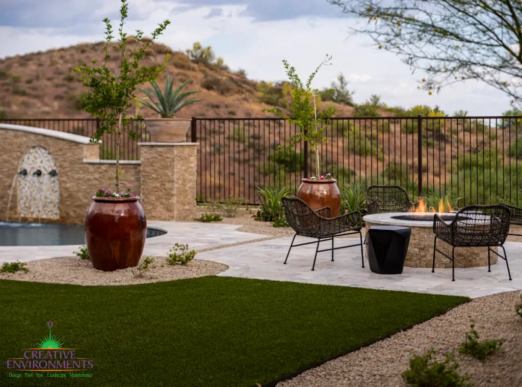 Custom backyard design with artificial turf, organized planting and large planters.