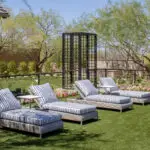 Custom backyard design with metal archway, water feature and lounge area.