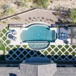 Custom backyard aerial view with unique shaped pool, putting green and artificial turf pattern.