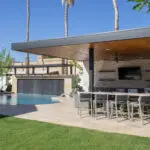 Backyard design with shade structure, outdoor kitchen and multiple dining areas.