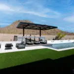 Custom backyard design with cantilevered shade structure, cantilevered fire table and blue pool.