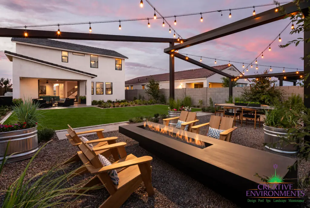 Backyard design with string lights, real grass and fire table.