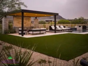 Custom backyard design with metal shade structure, artificial turf and multiple seating areas.