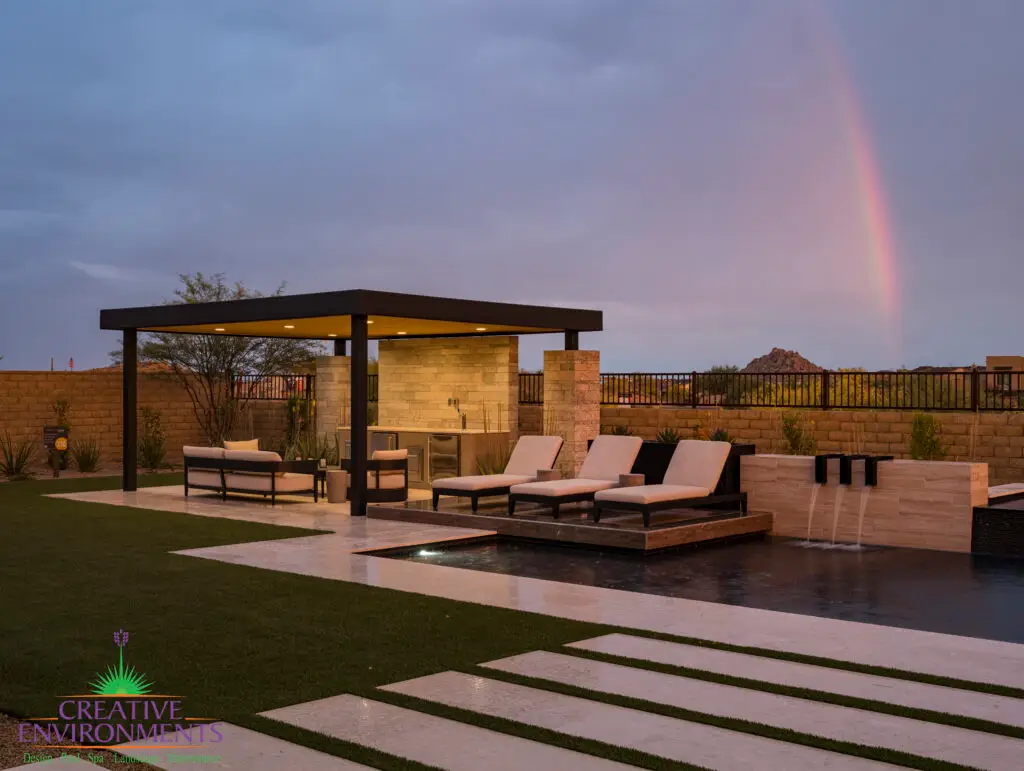 Custom backyard design with artificial turf, metal shade structure and natural stone accents.