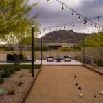 Custom backyard design with string lights, bocce ball court and organized planting.