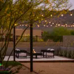 Custom backyard design with string lights, cantilevered fire table and bocce ball court.