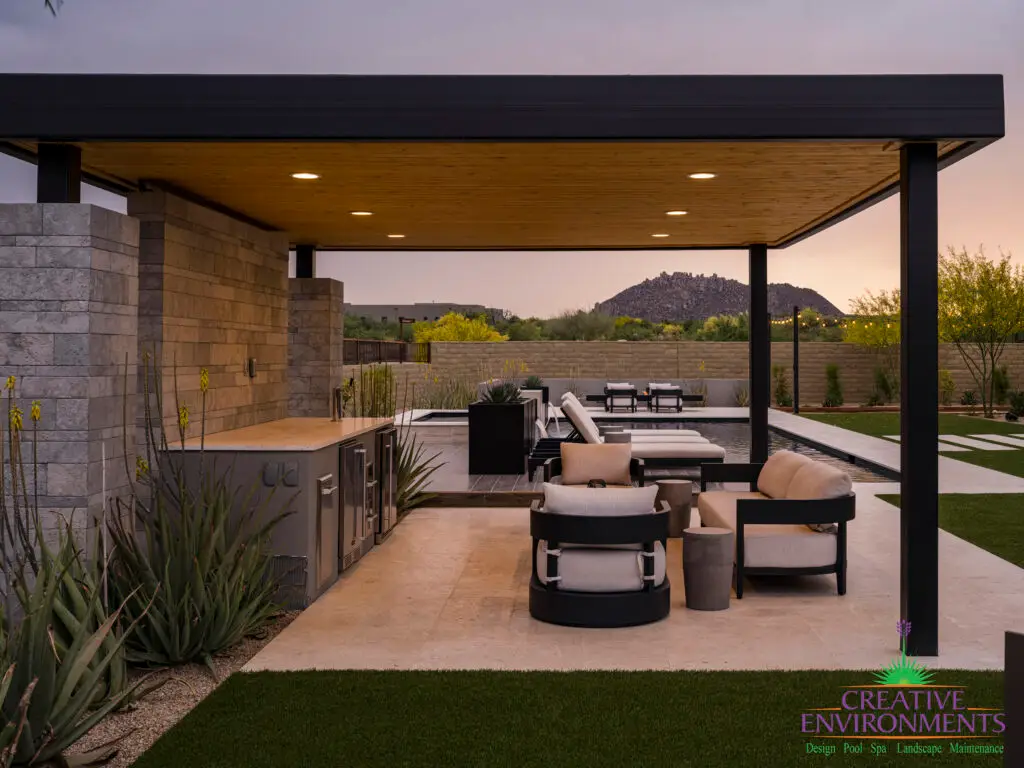 Custom backyard design with metal shade structure, outdoor entertainment area and artificial turf.