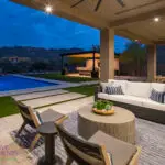 Custom backyard design with multiple seating areas, recessed lighting and outdoor fan.