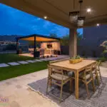 Custom backyard design with outdoor dining area, shade structure and artificial turf.