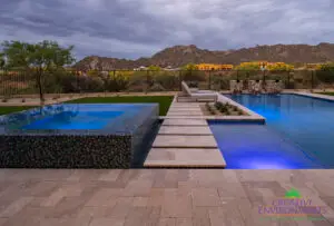 Custom backyard design blue raised spa, blue pool and water columns.