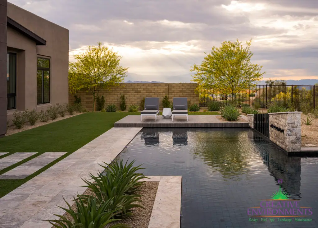 Custom backyard design with raised lounge area, artificial turf and desert landscape design.