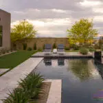 Custom backyard design with raised lounge area, artificial turf and desert landscape design.