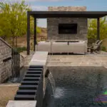 Custom backyard design with multiple angled water features, slatted metal statement piece and desert landscape design.