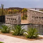 Custom backyard design with multiple water features, pool and desert landscape design.