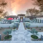 Custom front yard design with natural stone tile pathways, cacti and palm trees.