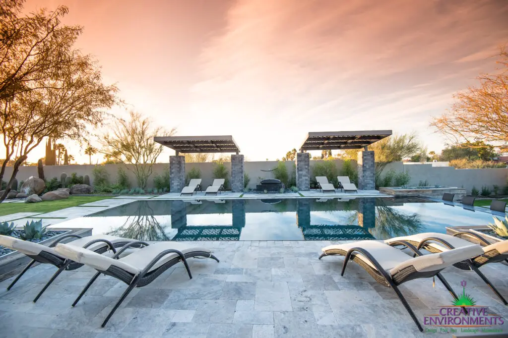 Custom backyard design with zero-edge pool, cantilevered shade structures and multiple seating areas.