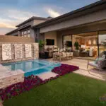 Custom backyard design with acrylic spa, natural stone accents and annuals.