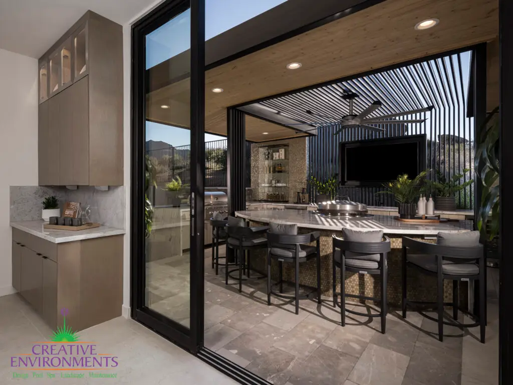 Backyard design with outdoor kitchen and recessed lighting.