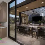 Backyard design with outdoor kitchen and recessed lighting.
