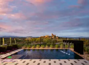 Custom backyard design with deco-tile decking, metal scupper water feature into pool and large planters.